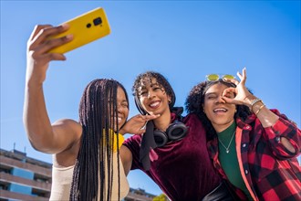 Low angle view photo of an african and muslim young women taking a selfie in the city