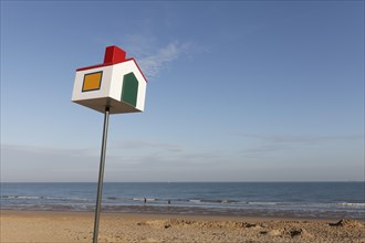 Pole with colourful little house for beach marking