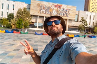 Selfie of a tourist blogger at the entrance to the National Historical Museum in Skanderbeg Square in Tirana. Albania