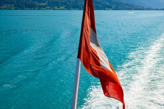 Swiss Flag over Lake Brienz in a Sunny Day in Interlaken