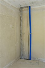 Electric cables and empty conduits on a wall