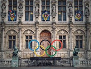 Close up Paris City Hall entrance. Outdoors view to the beautiful ornate facade of the historical building and the olympic games rings symbol in front of the central doors