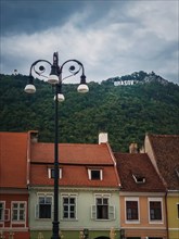 The old town of Brasov with colorful vintage buildings in traditional saxon style with the view to the sign on top of the hill. Popular tourist location in Romania