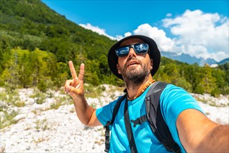 Selfie of a male hiker walking in the Valbona valley next to trees
