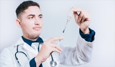 Handsome doctor holding syringe with antidote on isolated background. Closeup of doctor holding syringe and antidote isolated