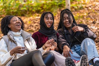Multicultural group of young women having fun sitting on a park
