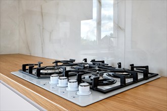 Modern built-in gass stove on wooden countertop