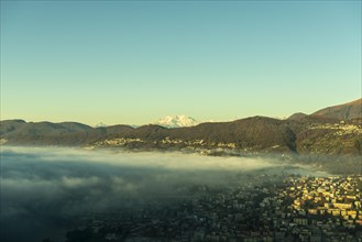 Snow-capped Mountain Peak Monte Rosa Above Cloudscape and Lake Lugano with Sunlight and Clear Sky in City of Lugano