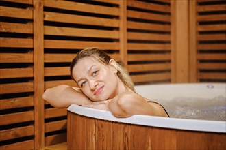 Lovely mid adult woman leaning on the edge of hot tub