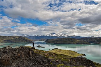 Tourist enjoying nature in Torres del Paine National Park with its snow-capped mountains and lakes