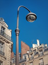 Retro style street lamp in an old Paris district with view to the blue sky background