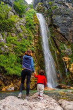 Mother with her son Grunas waterfall of Theth national park in summer
