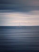 Seascape with a sailboat on the horizon