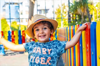 Portrait of a happy boy in hat playing in a playground