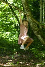 Girl gymnastics on a tree at the Wald Wasser Zauber Weg near Hintersee