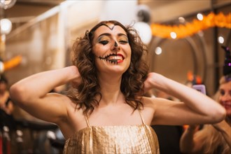 Portrait of a woman singing in costume and makeup at the halloween party in a disco nightclub
