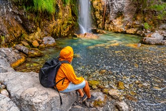 Tourist with backpack at Grunas waterfall in Theth national park