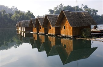 Bamboo raft huts with mirror image at Lake Ratchaprabha