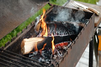 Metal grill with burning log and fork and knife for steak