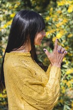 Side view of Kali mudra executed by a woman over nature background