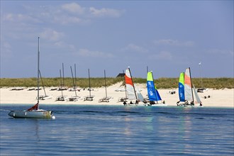 Sandy beach beach of the island Ile de Penfret with catamarans of the sailing school Les Glenans