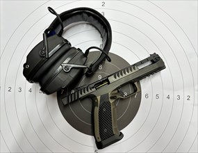 Handgun and Headphone Lying on a Shooting Target in Switzerland