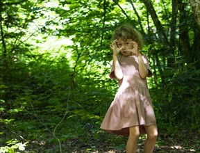 Playful girl gesticulating in the forest