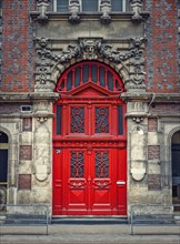 Vintage red door and ornate facade details of an old historical building in Rouen