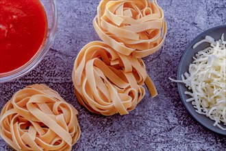 Raw egg tagliatelle pasta with tomato sauce and shredded cheese