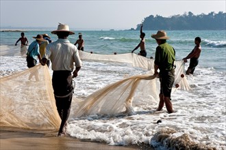 Fishermen pulling a net on the beach