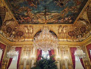 Beautiful decorated Napoleon apartments at Louvre palace. Royal family rooms with cardinal red curtains