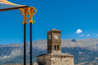 Colored arches in the Ottoman Castle Fortress of Gjirokaster or Gjirokastra and in the background the church with the clock tower. Albania