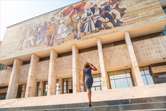A female tourist walking up the stairs to the National Historical Museum in Skanderbeg Square in Tirana. Albania