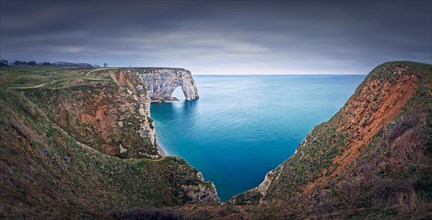 Sightseeing panoramic view to the Porte d'Aval natural arch cliff washed by Atlantic ocean waters at Etretat