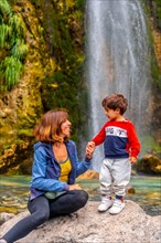 Portrait of mother with her son Grunas waterfall of Theth national park in summer
