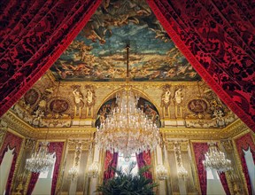 Beautiful decorated Napoleon apartments at Louvre palace. Royal family rooms with cardinal red curtains