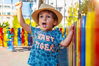 Portrait of happy little boy in hat playing on playground