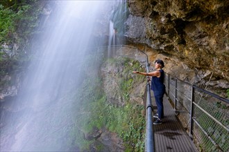Woman Behind The Giessbach Waterfall on the Mountain Side in Long Exposure in Brienz