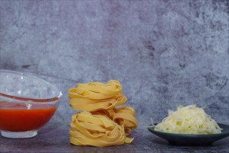 Raw egg tagliatelle pasta with tomato sauce and shredded cheese