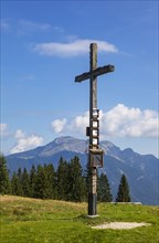 Summit cross on the Breitenberg with a view of the Schafberg