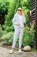Active woman in grey tracksuit in the garden