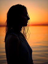 Silhouette of a young woman in the water at dusk
