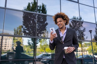 Cool businessman using the cellphone during a coffee break outdoors