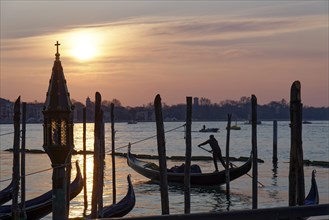 Gondola at sunrise on the Giudecca Canal in front of St Mark's Square