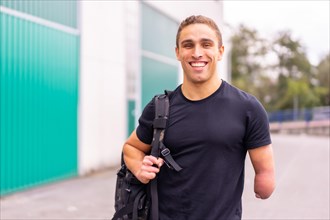 Happy and young disabled sports man arriving at the gym