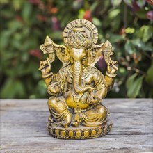 Ganesha statue sitting in meditating yoga pose on a trunk