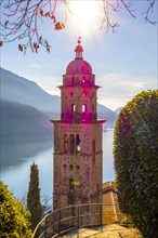 Church Tower Santa Maria del Sasso with Sunlight and Bare Tree and Mountain on Lake Lugano in Morcote