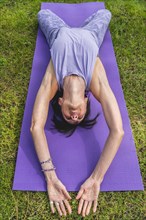 Hihg angle view of a woman lying on a yoga block to improving posture