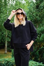 Woman in sunglasses wearing hoodie and fleece trousers outdoors