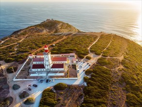 Aerial drone view of lighthouse on Cabo Espichel cape Espichel on Atlantic ocean at sunset. Sesimbra